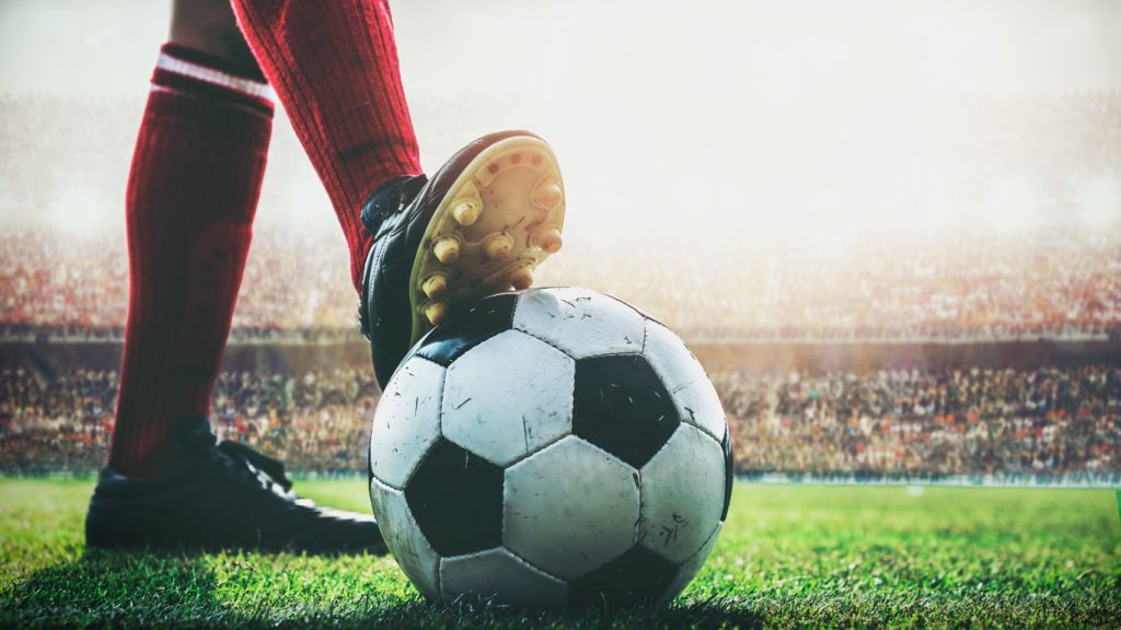Premier League: jogador com o pé em cima da bola durante partida (iStock).