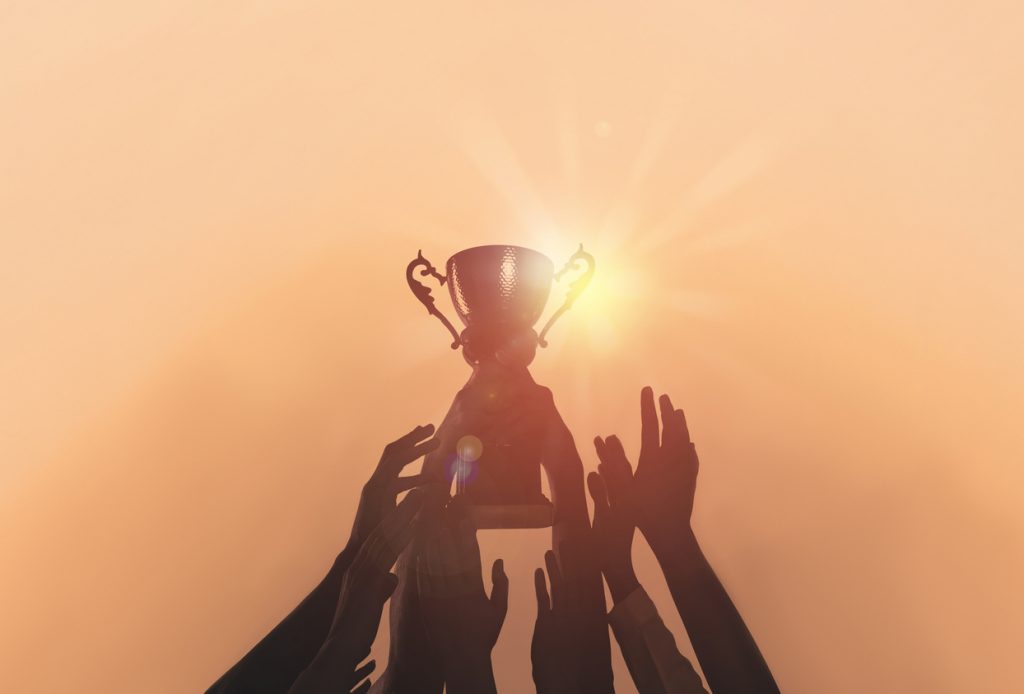 Libertadores: pessoas erguendo troféu (iStock).